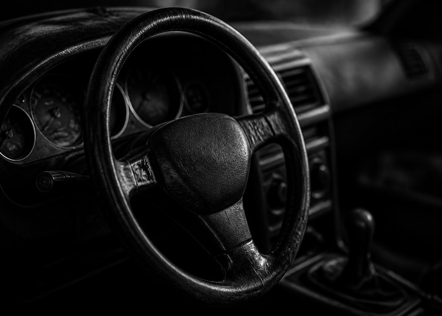 Detail of a worn car steering wheel and dashboard